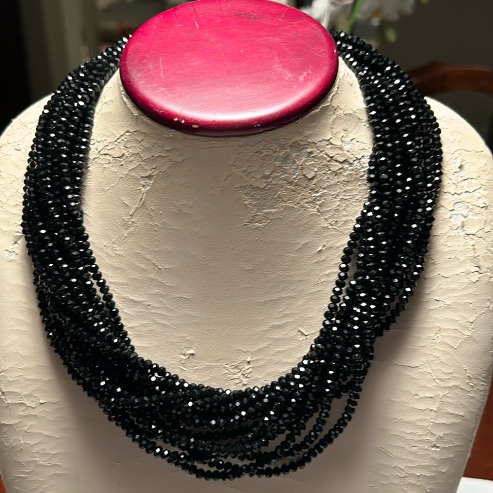 A multi - strand black crystal necklace.